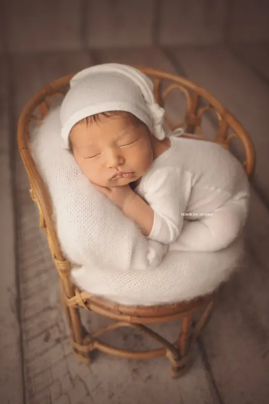 Photo nouveau-né à Orléans, instant tendre avec bébé, portrait vertical soigné, couleurs équilibrées