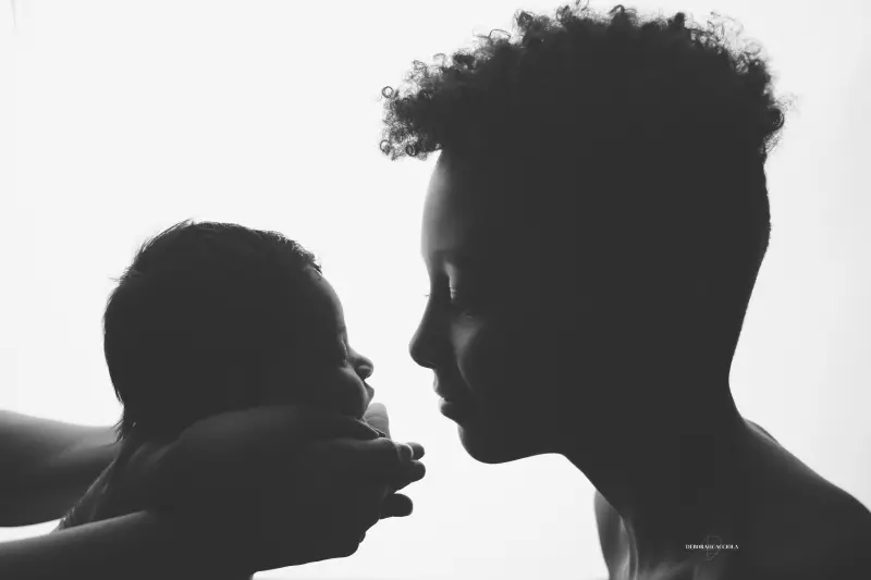 Portrait nouveau-né à Orléans : instant tendre avec bébé, plan large harmonieux, contraste noir et blanc