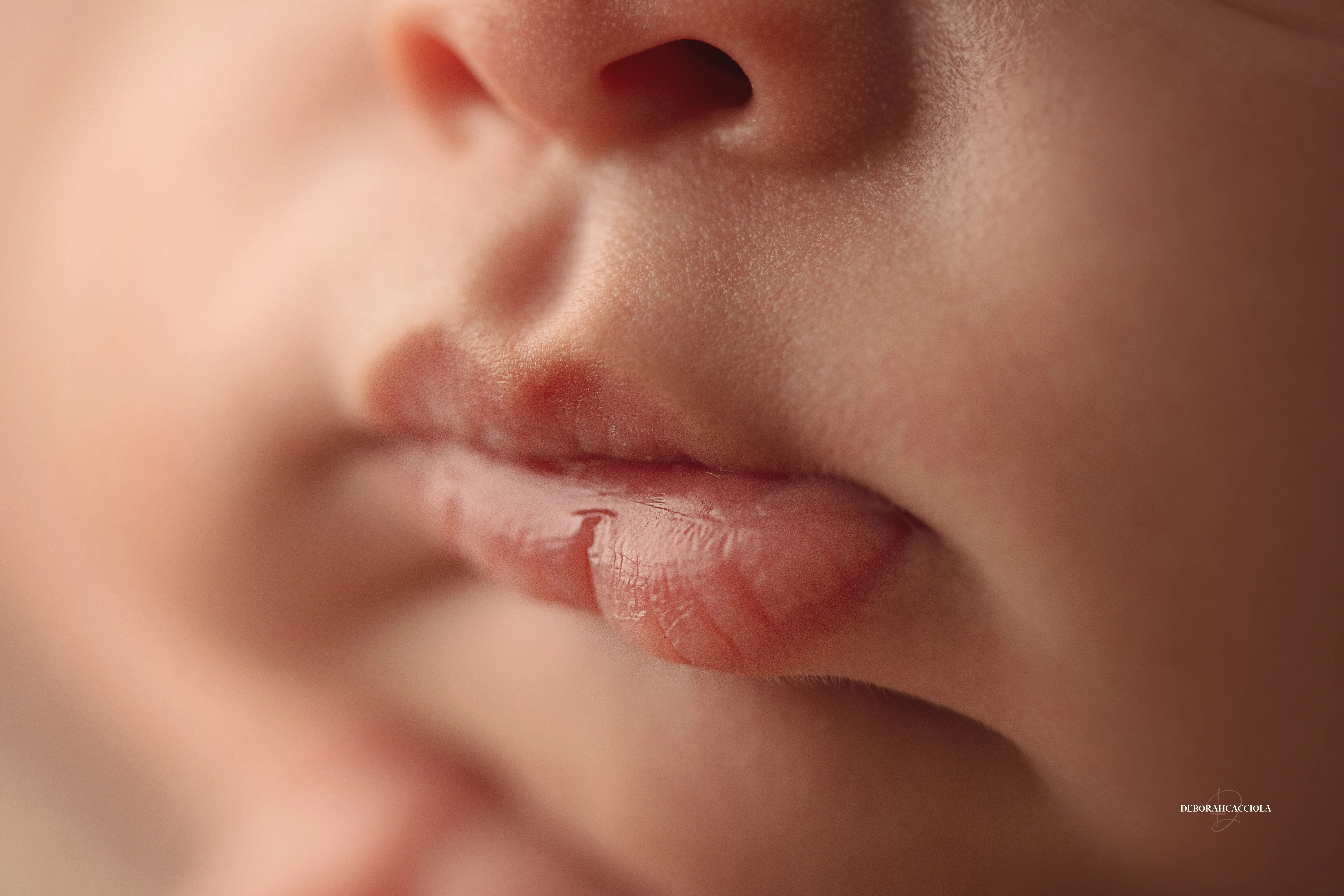 Portrait nouveau-né à Orléans : instant tendre avec bébé, plan large harmonieux, palette claire