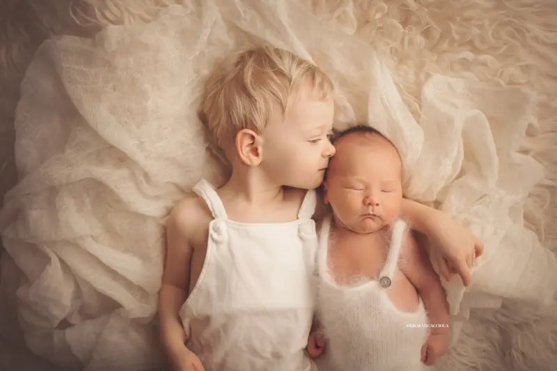 Portrait nouveau-né à Orléans : instant tendre avec bébé, plan large harmonieux, couleurs douces