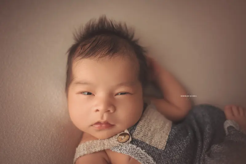 Photo nouveau-né studio Orléans : portrait délicat de bébé, cadrage horizontal équilibré, tonalités naturelles