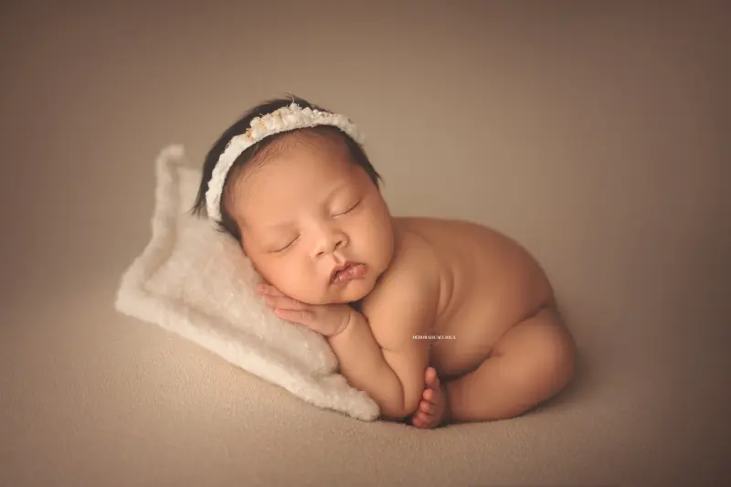 Séance bébé en studio à Orléans : portrait délicat de bébé, cadrage horizontal équilibré, palette claire