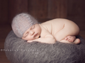Photo nouveau-ne Photo de bébé sur une boule de laine grise
