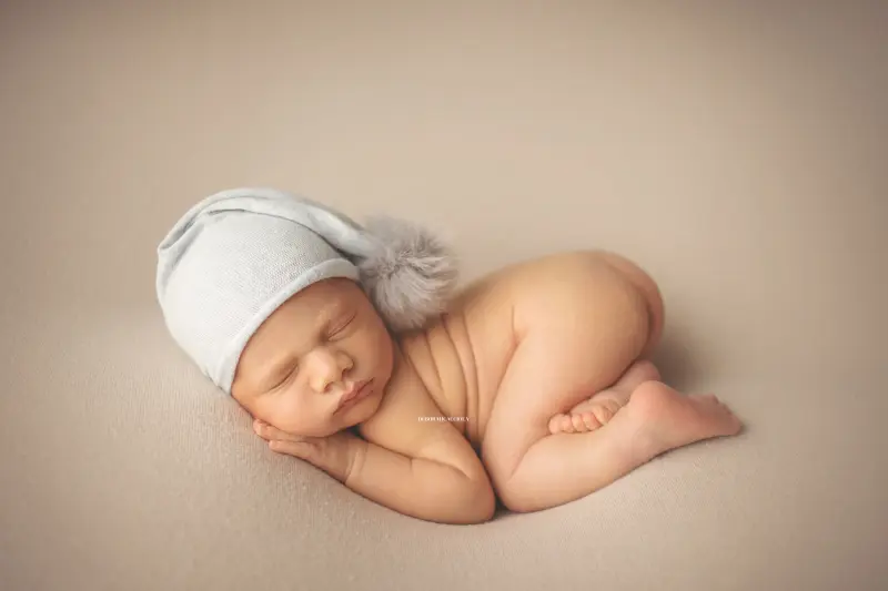 Séance bébé en studio à Orléans : portrait délicat de bébé, cadrage horizontal équilibré, palette claire