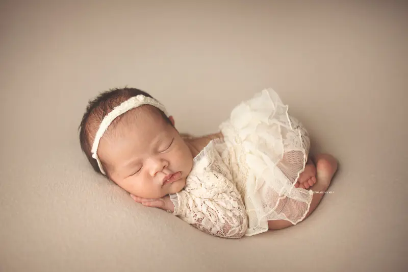 Séance bébé en studio à Orléans : portrait délicat de bébé, cadrage horizontal équilibré, couleurs douces