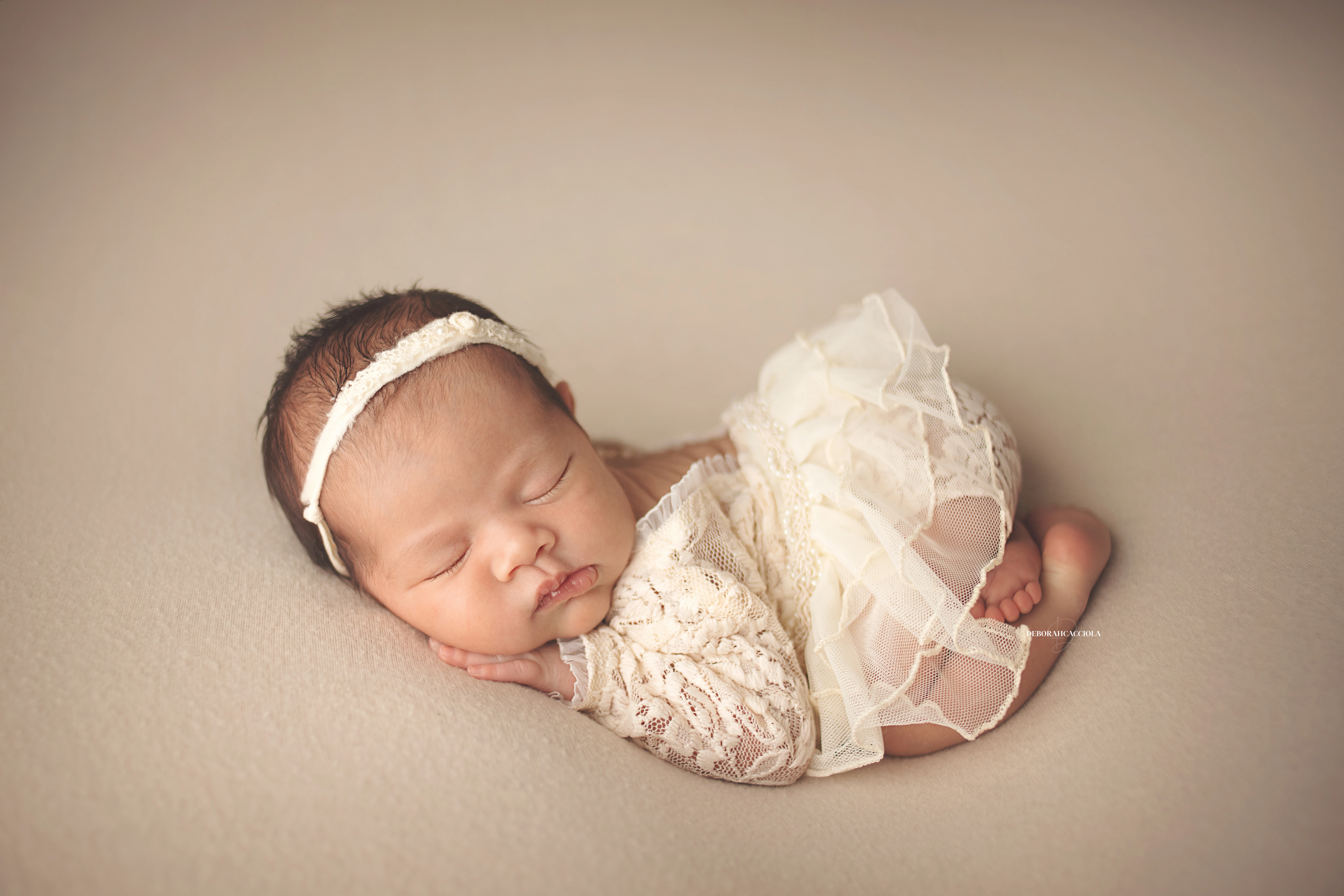 Séance bébé en studio à Orléans : portrait délicat de bébé, cadrage horizontal équilibré, couleurs douces