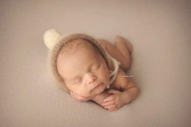 Photo nouveau-né studio Orléans : portrait délicat de bébé, cadrage horizontal équilibré, rendu naturel