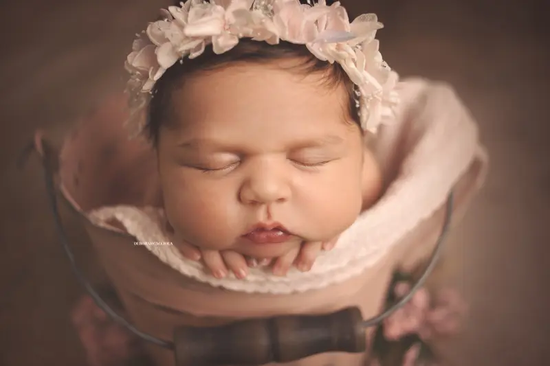 Séance bébé en studio à Orléans : nouveau-né en studio, scène panoramique douce, palette claire