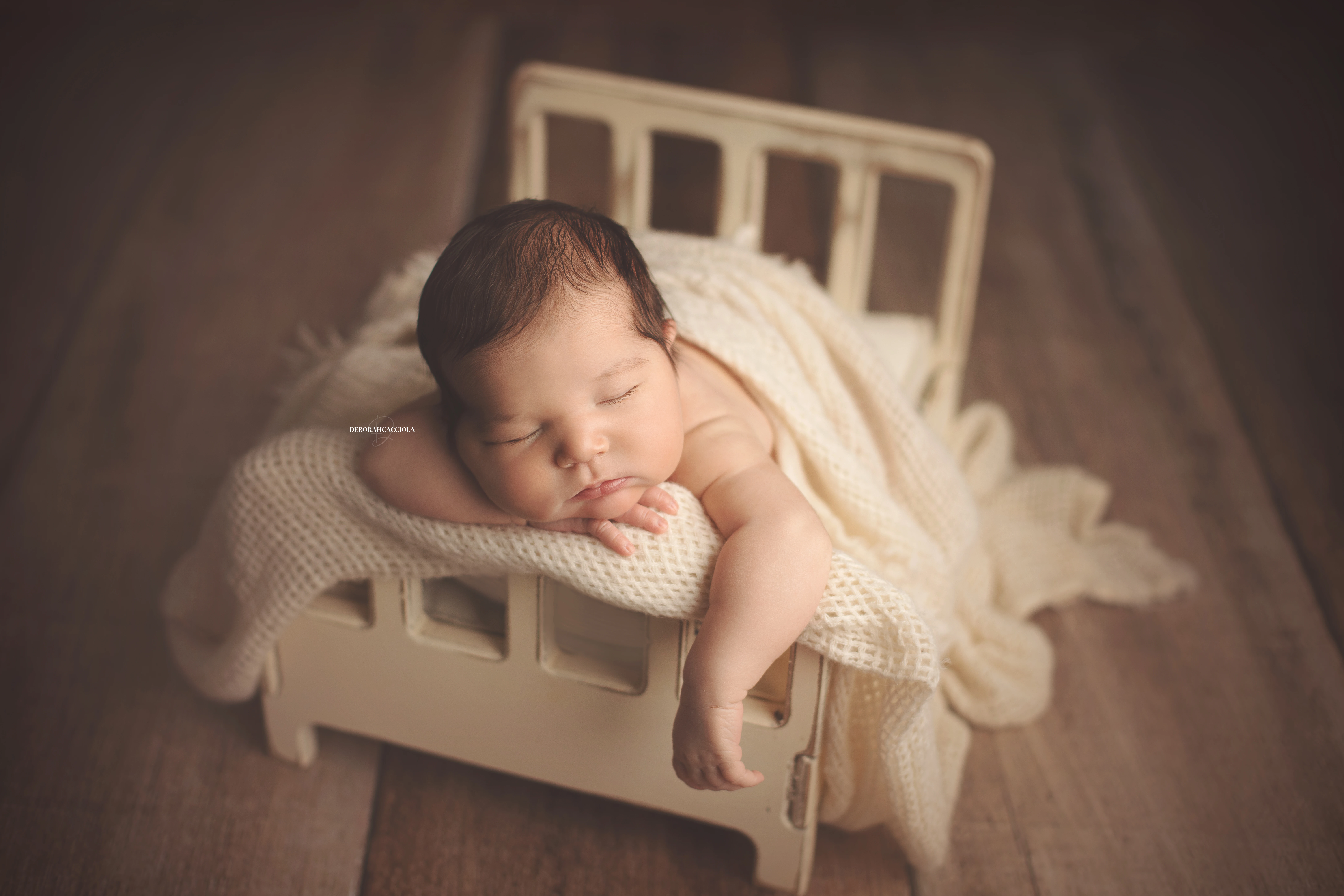 Séance bébé en studio à Orléans : nouveau-né en studio, scène panoramique douce, couleurs douces