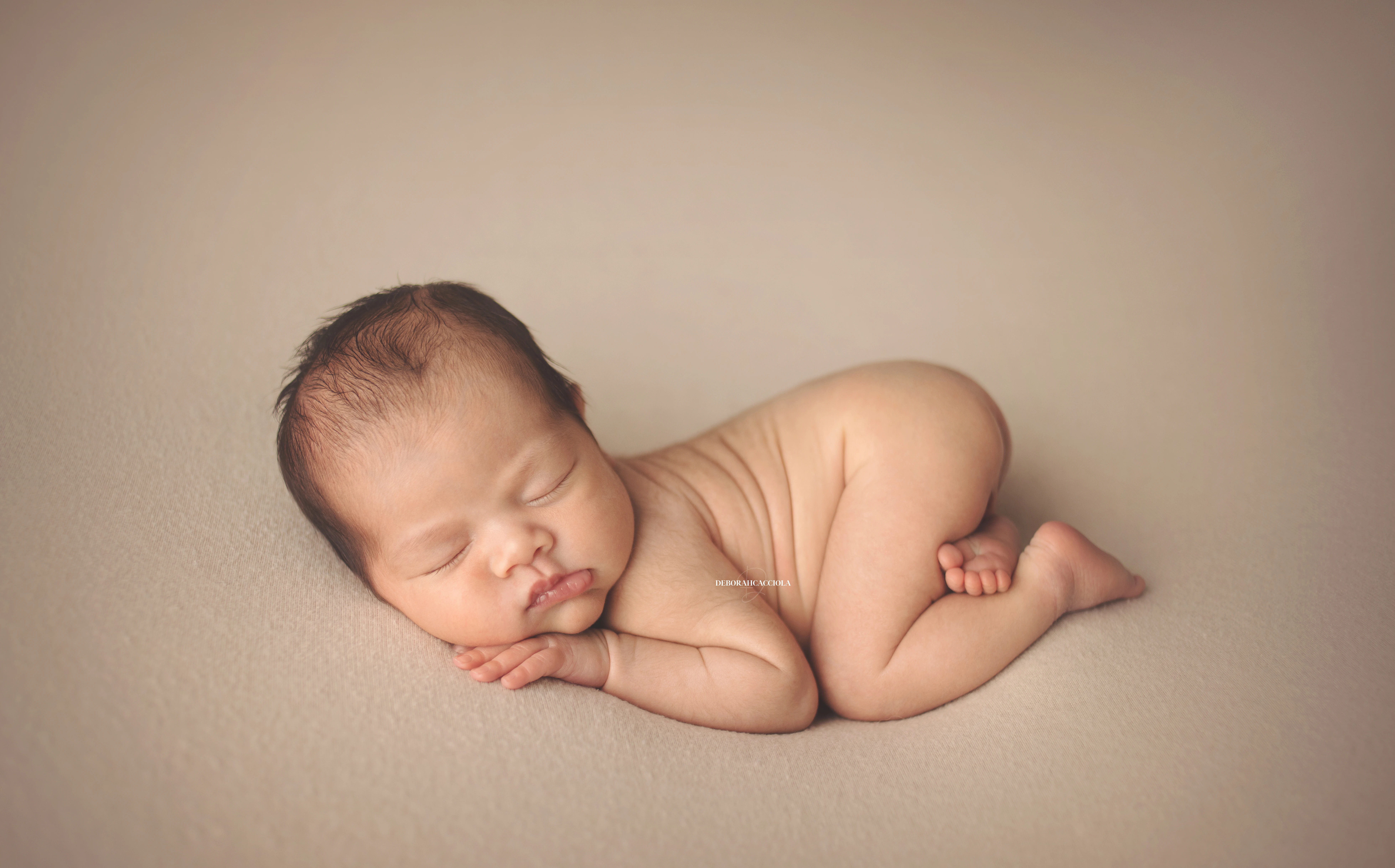 Séance bébé en studio à Orléans : nouveau-né en studio, scène panoramique douce, couleurs équilibrées