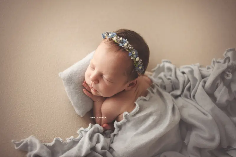 Portrait nouveau-né à Orléans : bébé dans ses premiers jours, composition large et naturelle, palette claire