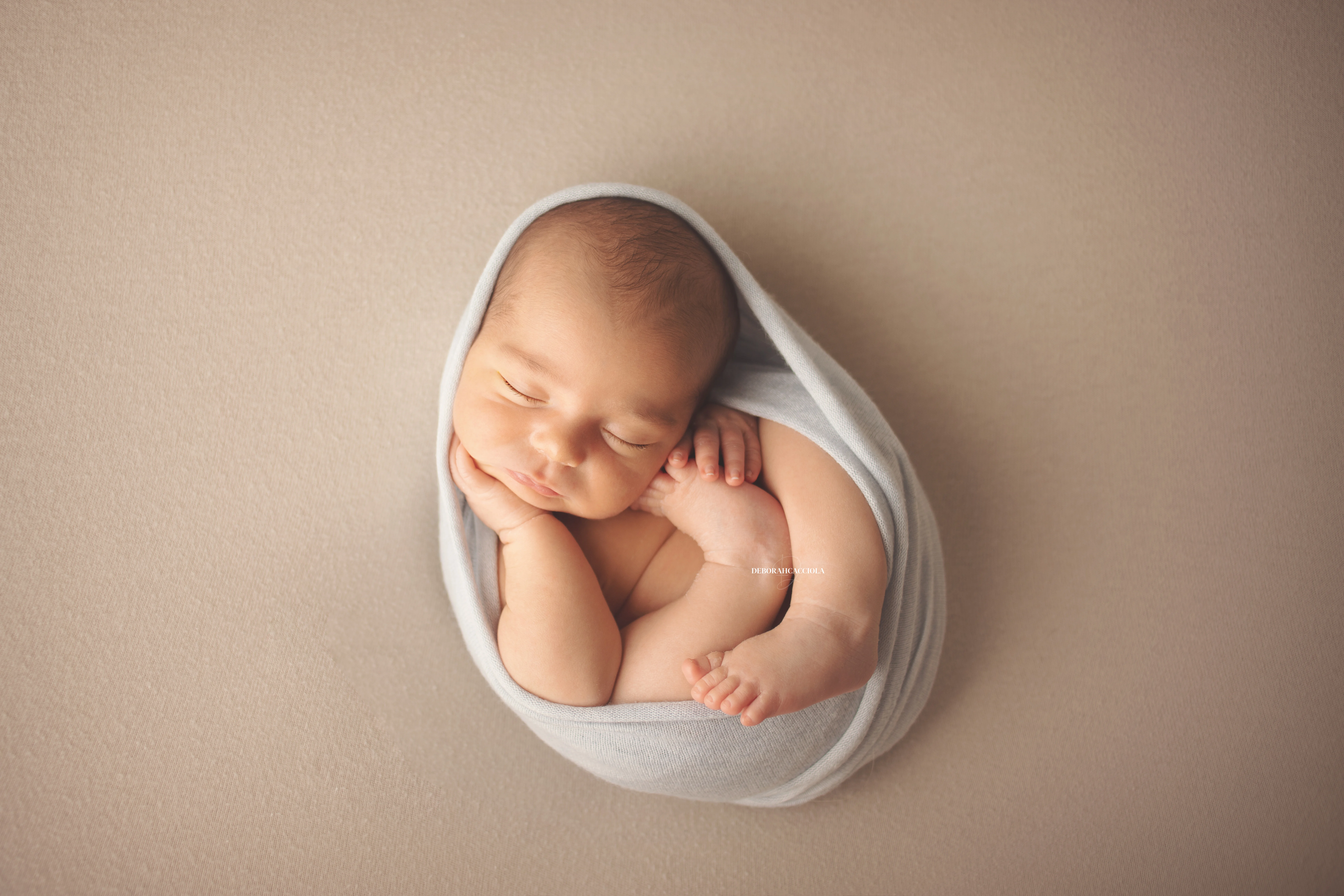 Séance bébé en studio à Orléans : portrait délicat de bébé, cadrage horizontal équilibré, palette claire