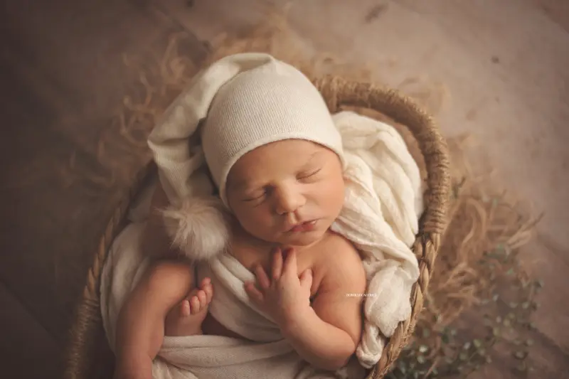 Photo nouveau-né studio Orléans : portrait délicat de bébé, cadrage horizontal équilibré, couleurs douces