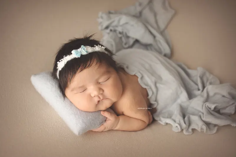 Photo nouveau-né studio Orléans : nouveau-né en studio, scène panoramique douce, palette claire