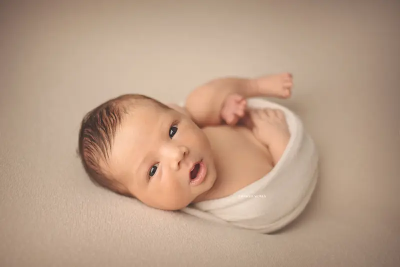 Portrait nouveau-né à Orléans : bébé dans ses premiers jours, composition large et naturelle, tonalités naturelles