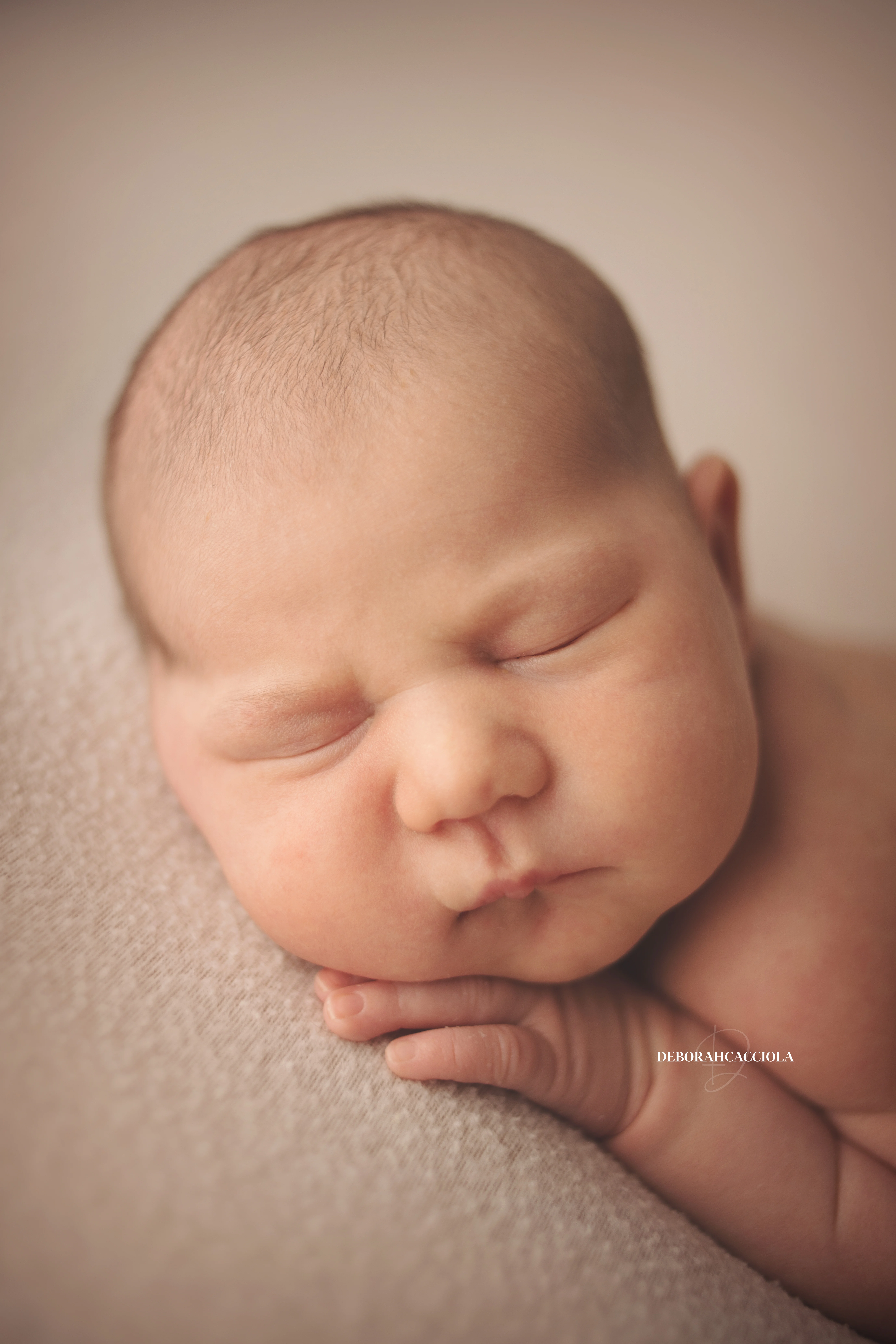 Portrait nouveau-né Orléans : nouveau-né en studio, cadrage vertical doux, tonalités naturelles