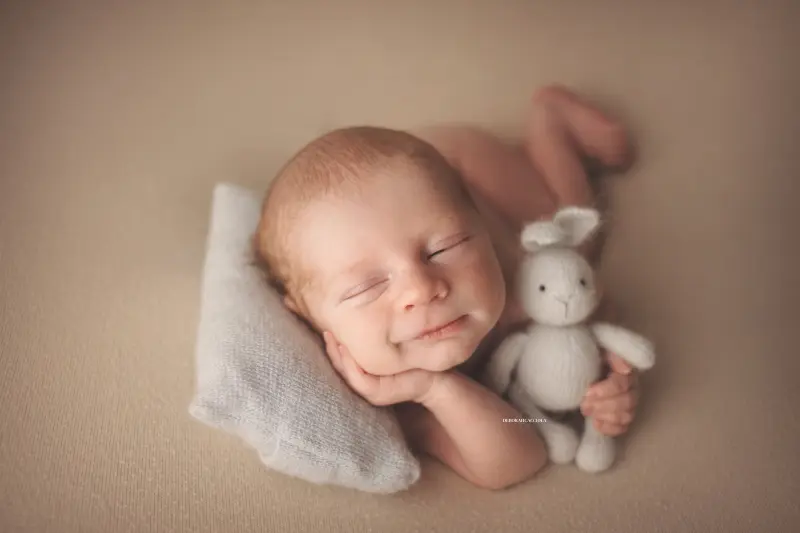Séance bébé en studio à Orléans : portrait délicat de bébé, cadrage horizontal équilibré, palette claire