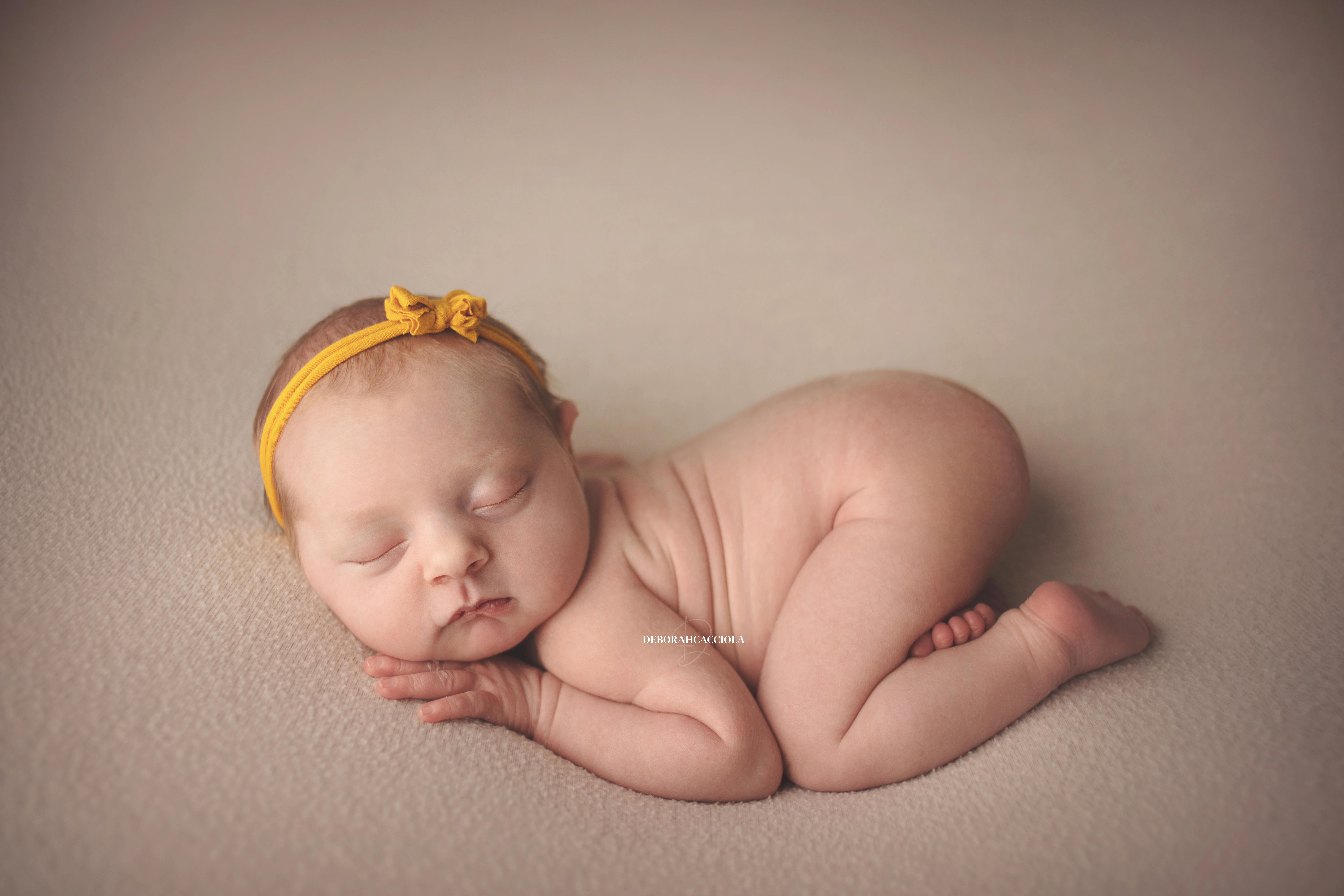 Séance bébé en studio à Orléans : portrait délicat de bébé, cadrage horizontal équilibré, couleurs douces