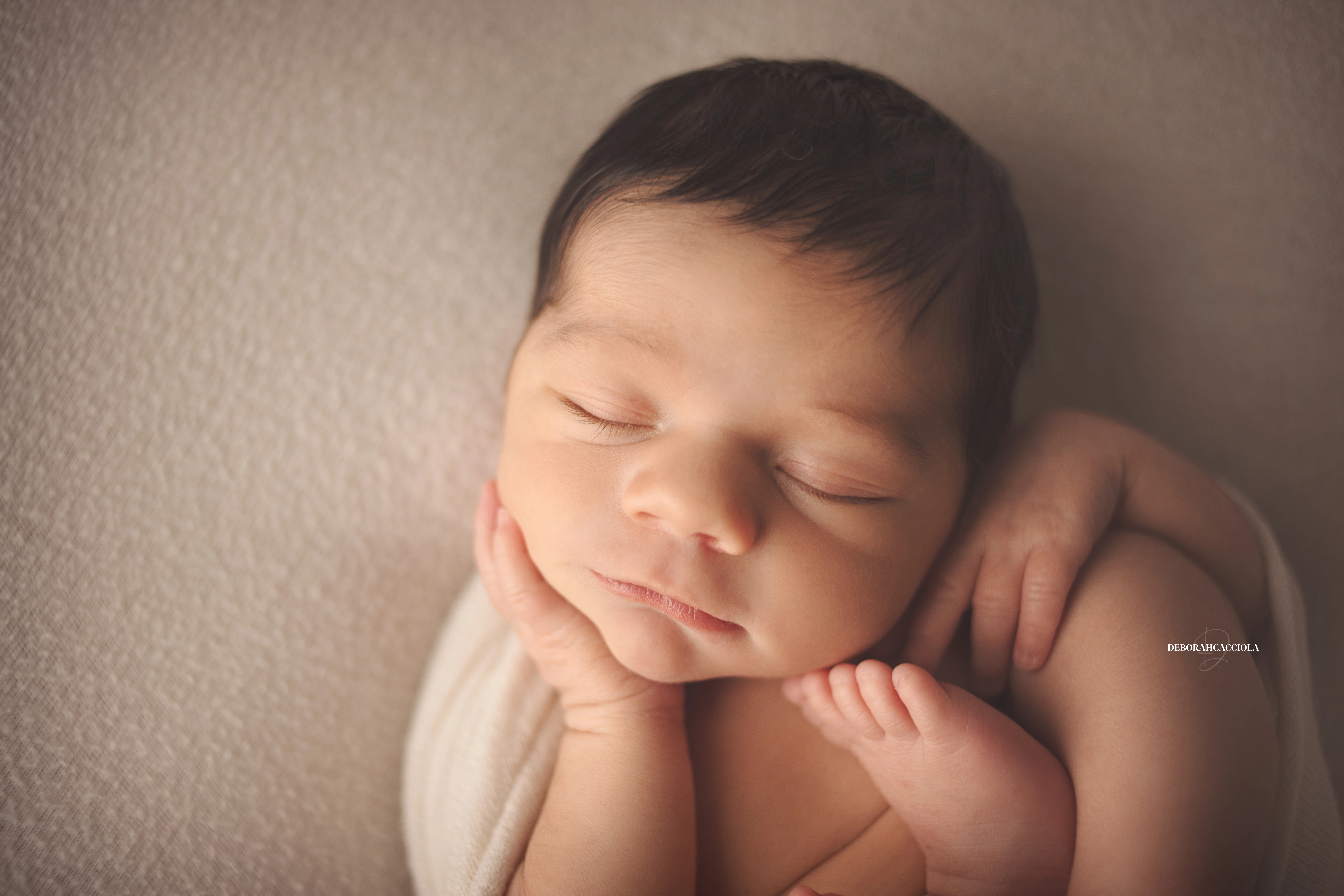 Photo nouveau-né studio Orléans : portrait délicat de bébé, cadrage horizontal équilibré, couleurs douces