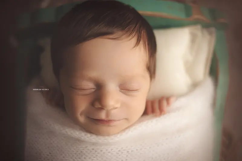 Photo nouveau-né studio Orléans : portrait délicat de bébé, cadrage horizontal équilibré, couleurs douces