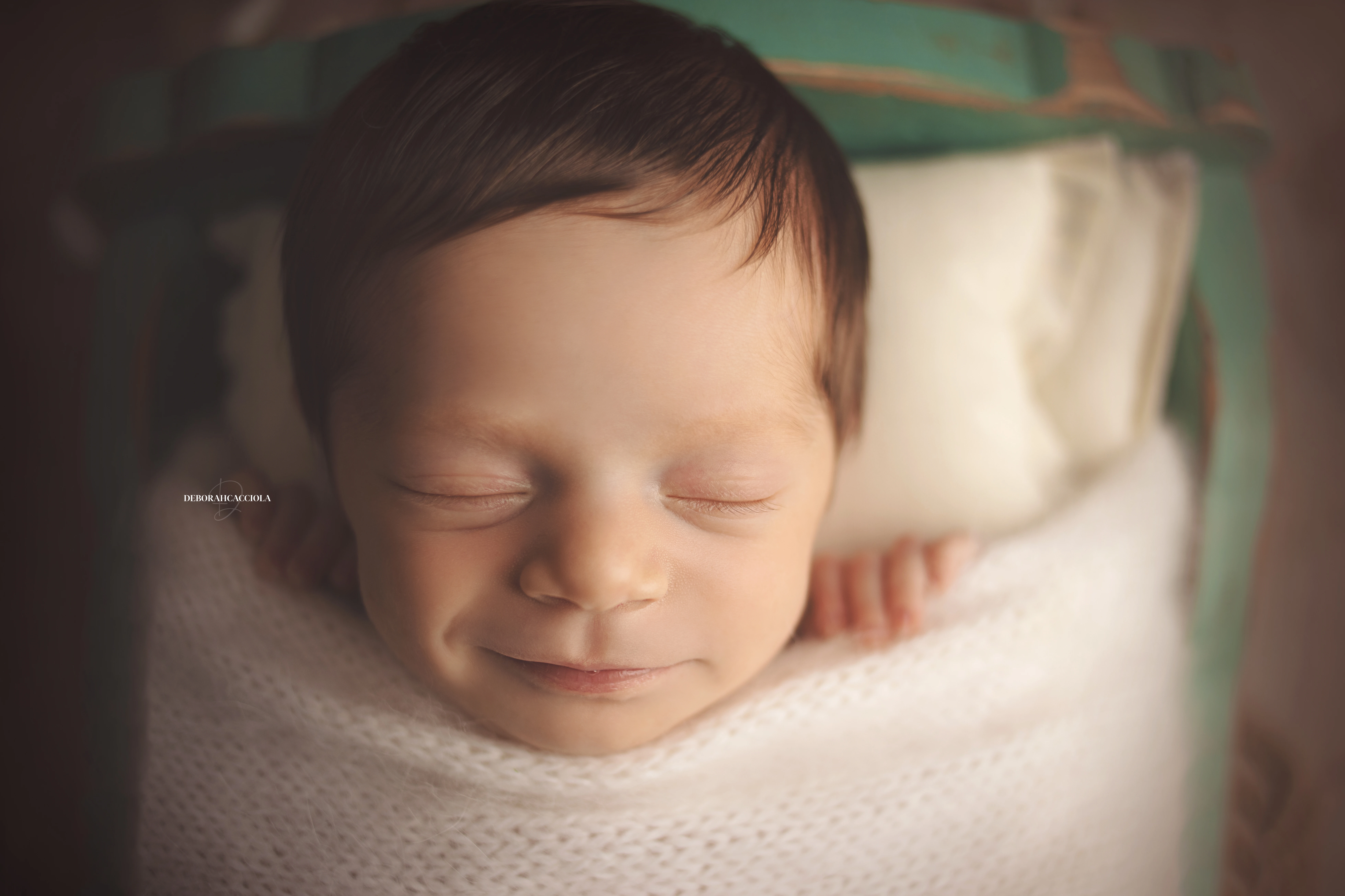 Photo nouveau-né studio Orléans : portrait délicat de bébé, cadrage horizontal équilibré, couleurs douces