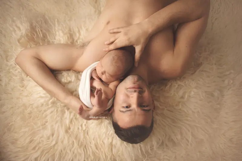 Portrait nouveau-né à Orléans : instant tendre avec bébé, plan large harmonieux, couleurs équilibrées