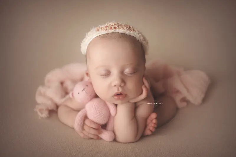 Séance bébé en studio à Orléans : portrait délicat de bébé, cadrage horizontal équilibré, couleurs douces