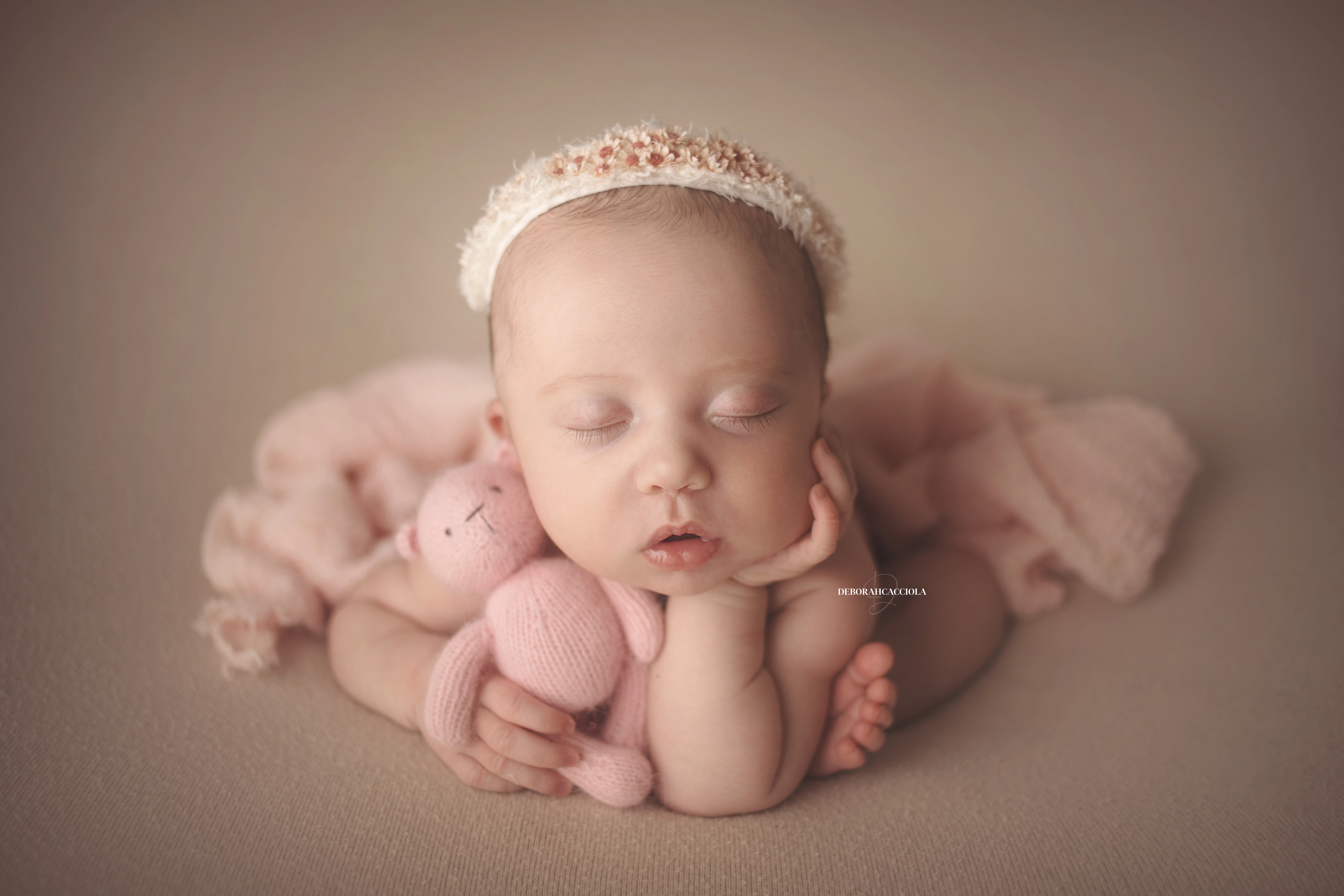 Séance bébé en studio à Orléans : portrait délicat de bébé, cadrage horizontal équilibré, couleurs douces