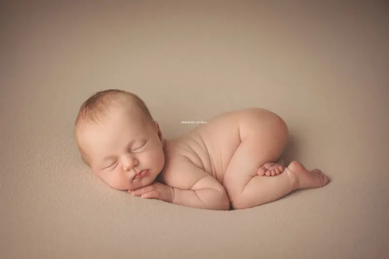Séance bébé en studio à Orléans : portrait délicat de bébé, cadrage horizontal équilibré, couleurs équilibrées