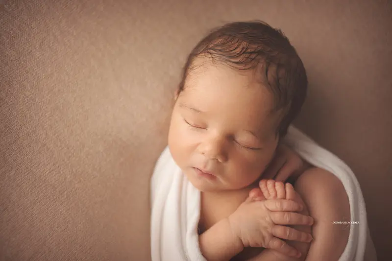 Séance bébé en studio à Orléans : portrait délicat de bébé, cadrage horizontal équilibré, rendu naturel