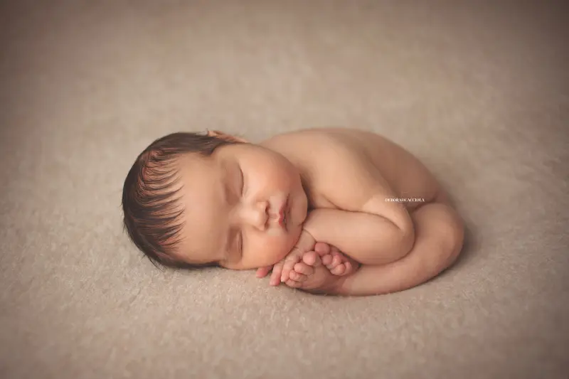 Séance bébé en studio à Orléans : portrait délicat de bébé, cadrage horizontal équilibré, rendu naturel