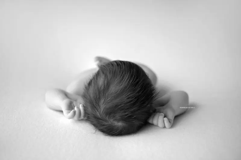 Photo nouveau-né à Orléans, bébé dans ses premiers jours, composition large et naturelle, style noir et blanc