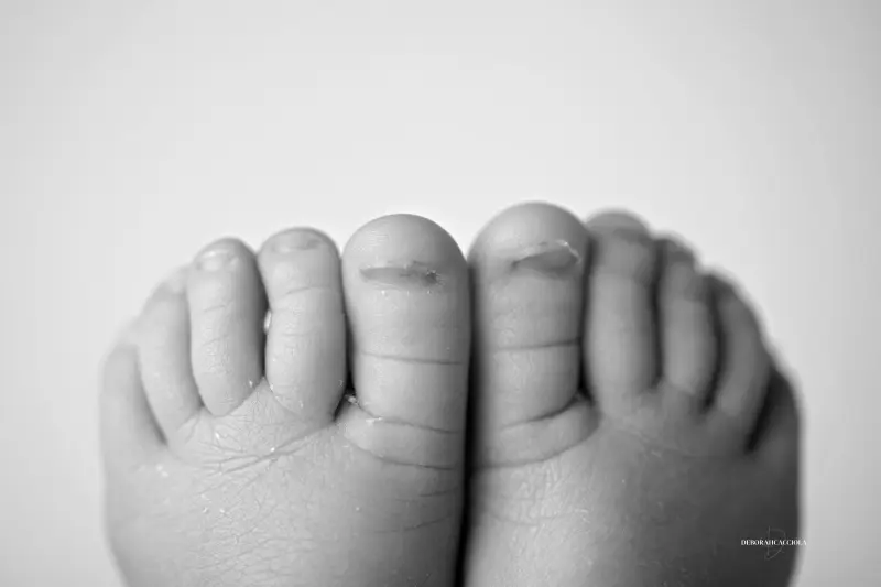 Séance bébé en studio à Orléans : portrait délicat de bébé, cadrage horizontal équilibré, rendu monochrome