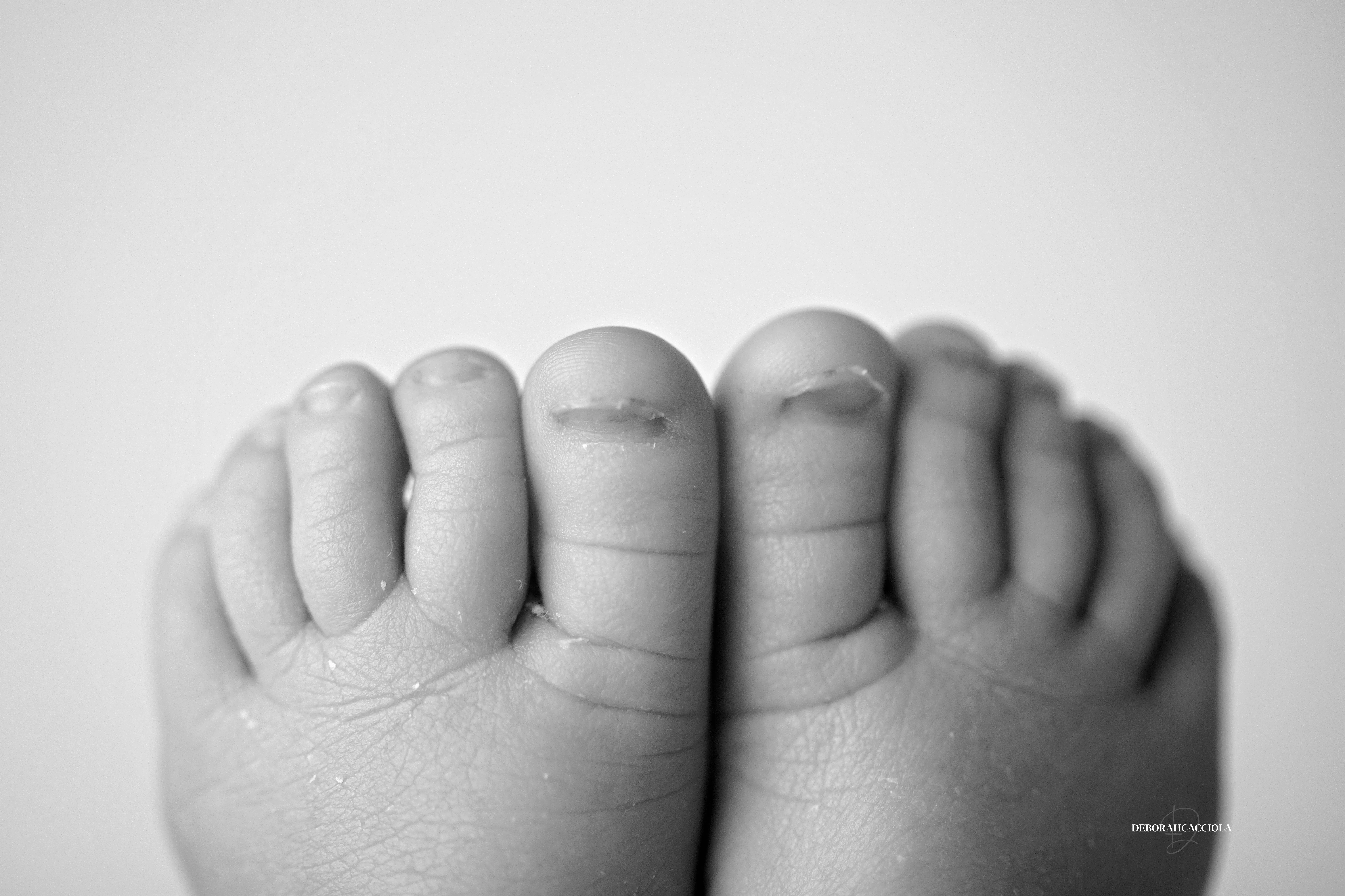 Séance bébé en studio à Orléans : portrait délicat de bébé, cadrage horizontal équilibré, rendu monochrome