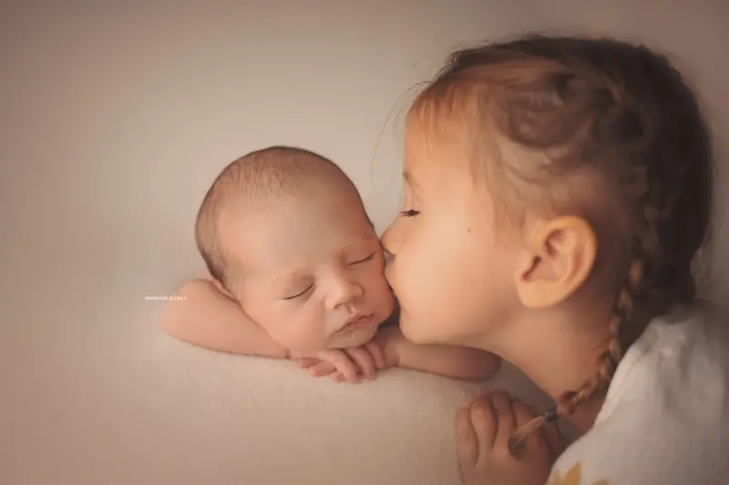 Photo nouveau-né à Orléans, instant tendre avec bébé, plan large harmonieux, couleurs douces