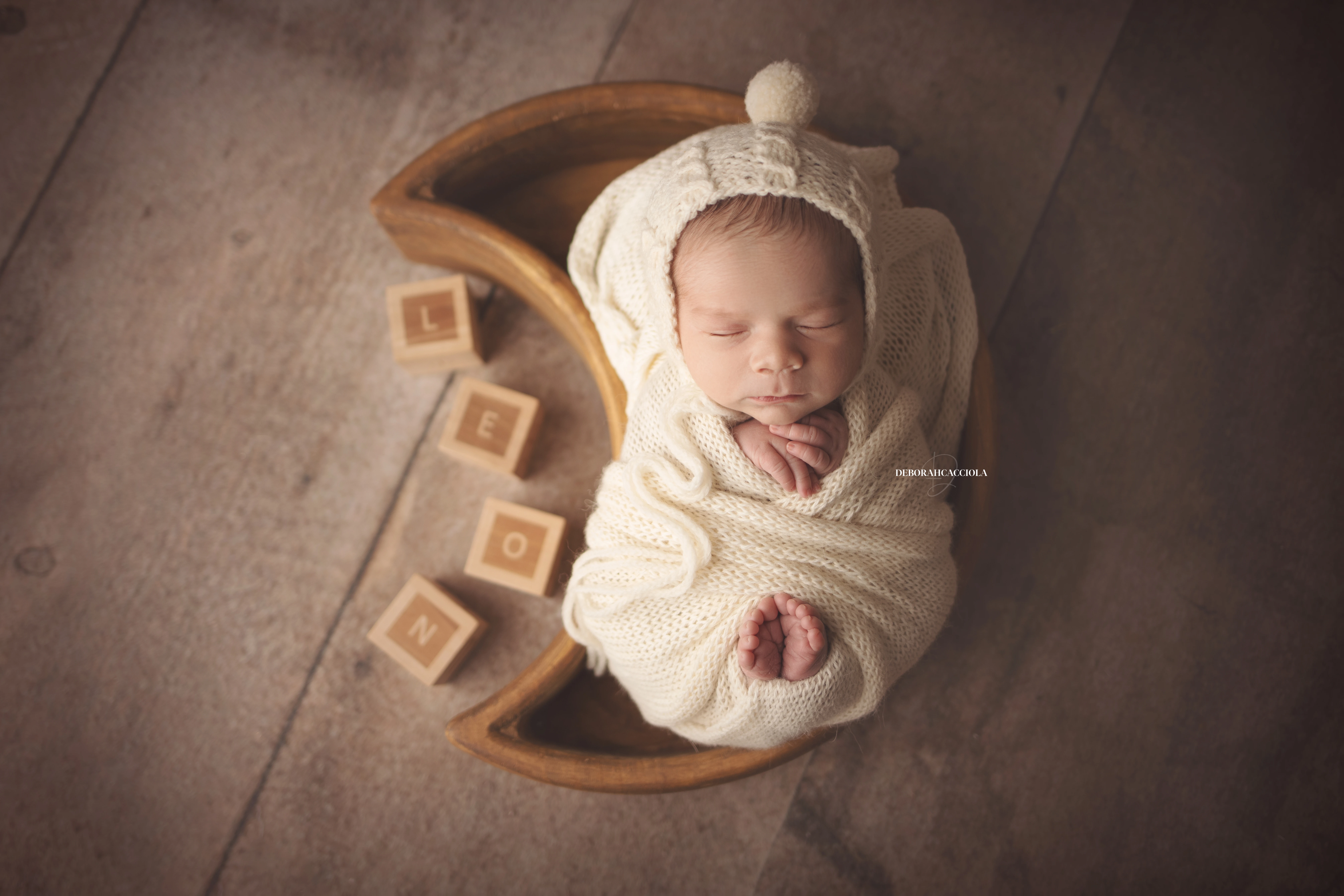 Photo nouveau-né studio Orléans : portrait délicat de bébé, cadrage horizontal équilibré, couleurs douces